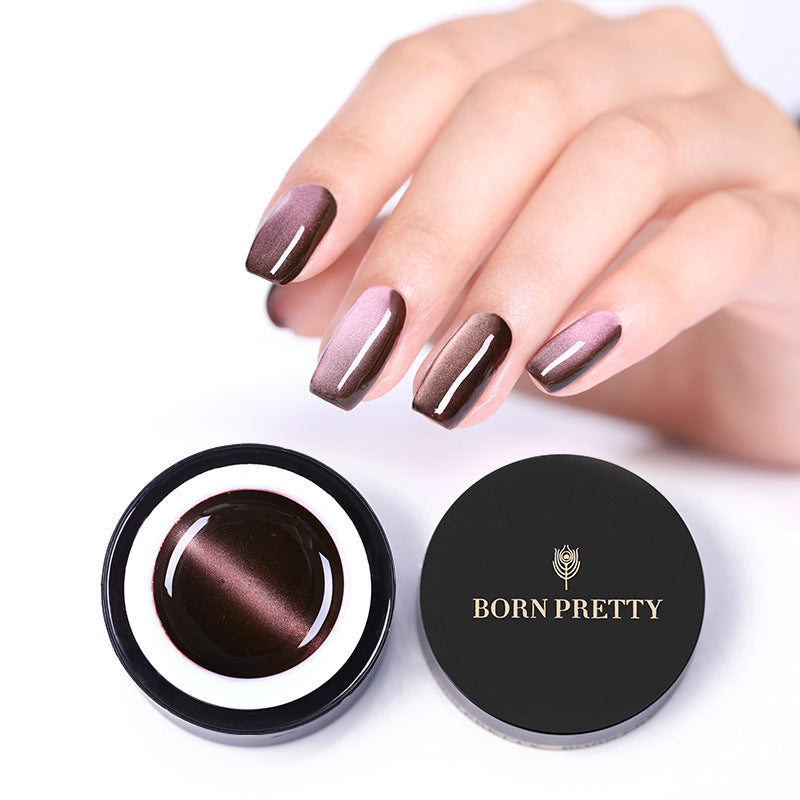 Hand with brown nail polish holding a container of 'Born Pretty' nail gel polish.