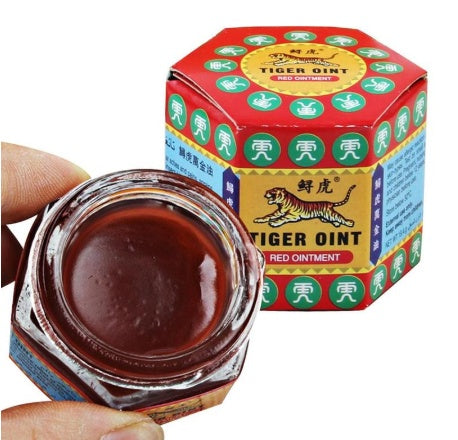 Red jar of Tiger Balm ointment with its packaging on a white background