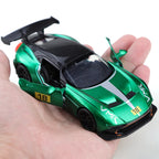 Green toy car held in a hand with a white background